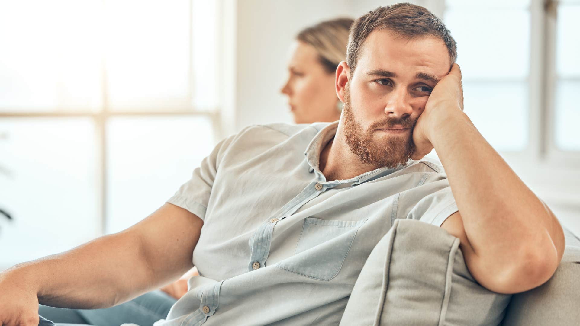 burnt out man turned away from his wife at home