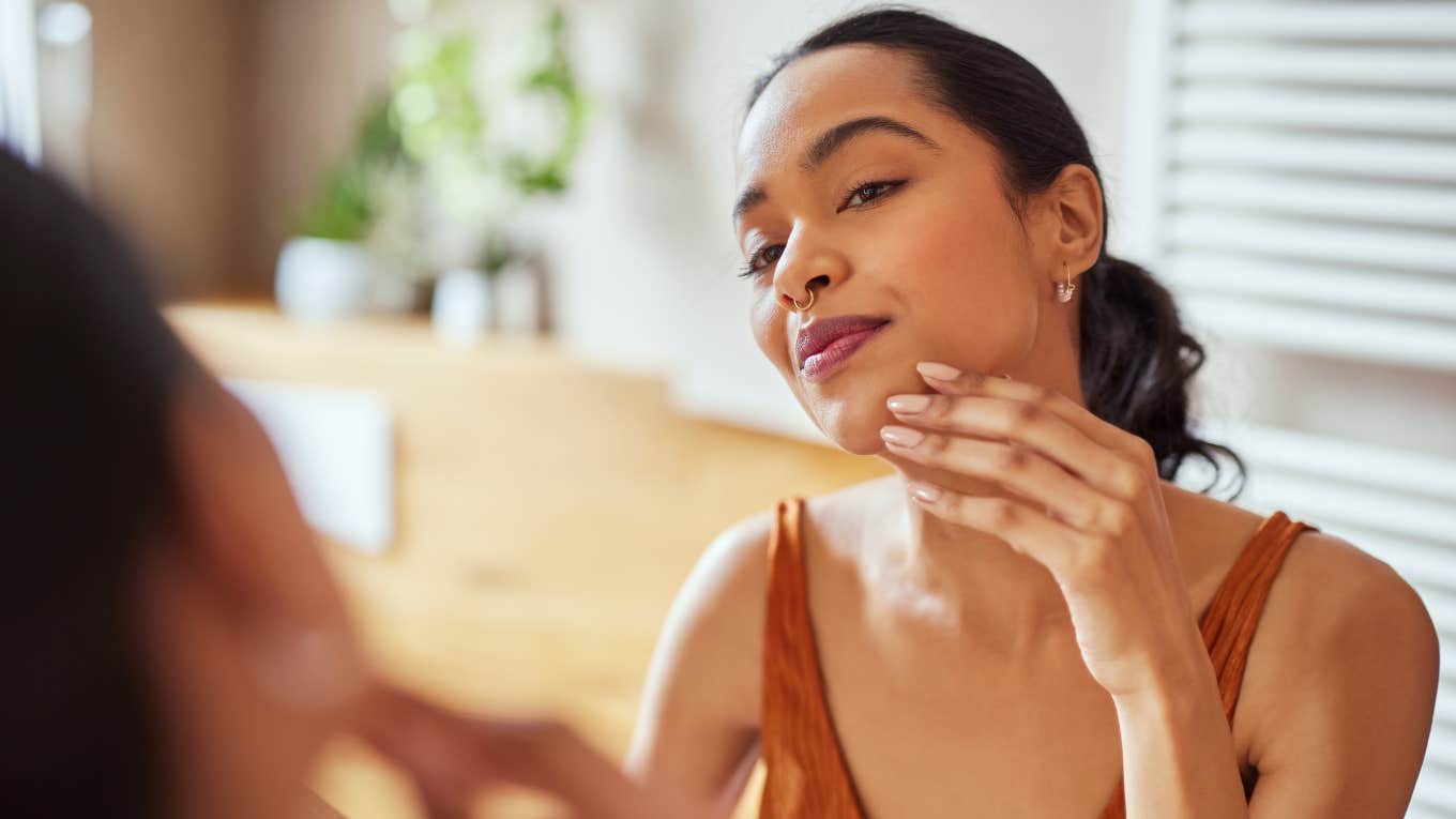 Hygiene Mistakes That Make People Stink woman making bad hygiene mistake touching her face