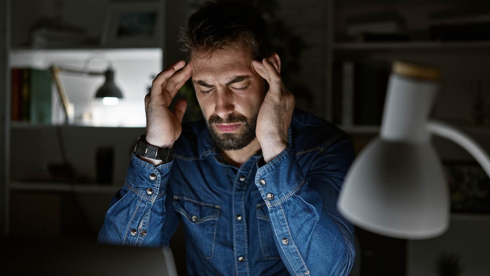 man avoiding de-stressing rituals holding his temples