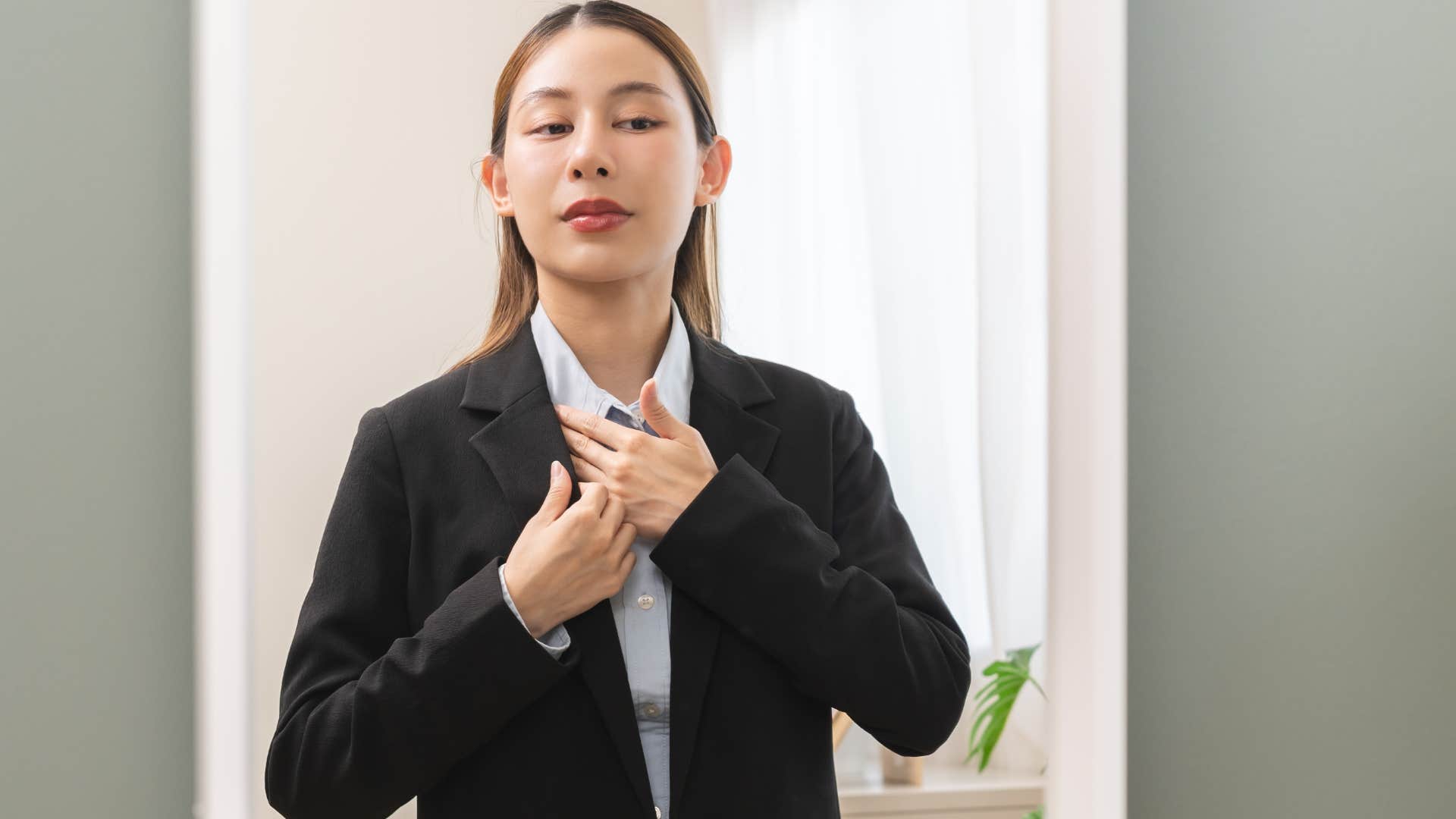 woman wearing non-breathable clothing looking in a mirror
