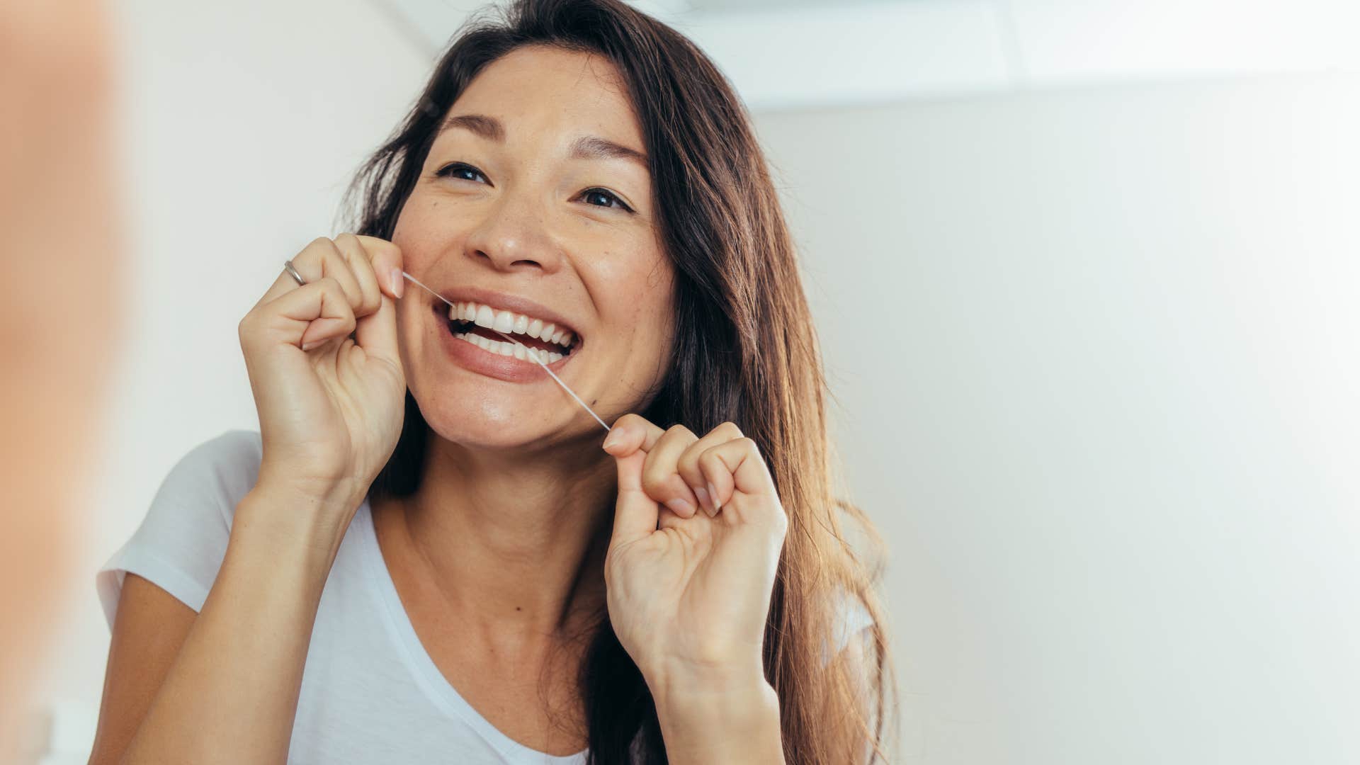 woman who's doesnt floss looking in the mirror
