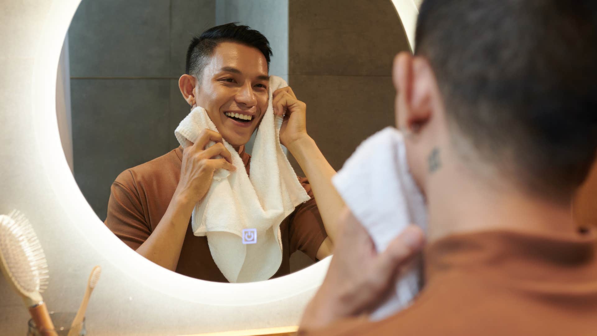 man washing face not his entire body looking in mirror