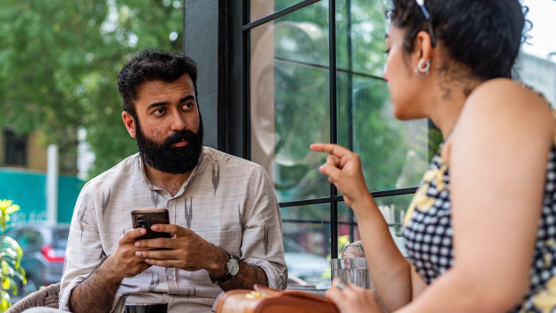 man with immature behavior of using phone on date