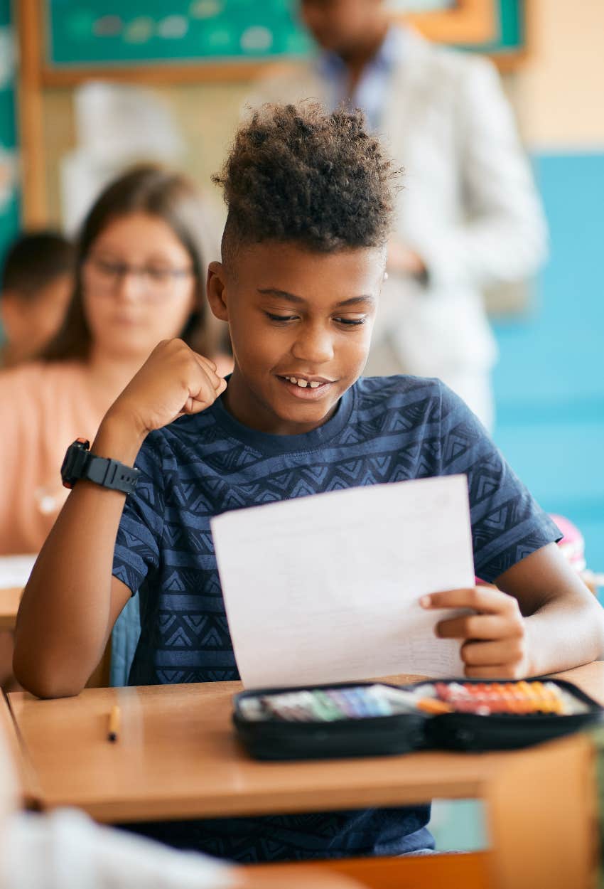 kid happy he got good grades and can get free groceries