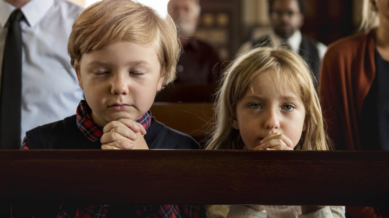 Kids Who Grow Up In Non-Religious Homes May Be More Generous, According To Research two young kids praying in church are more selfish than kids who grow up in non-religious homes