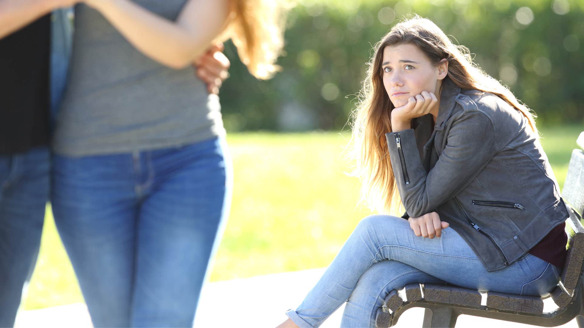 sad woman looking at couple remembering how they made her feel