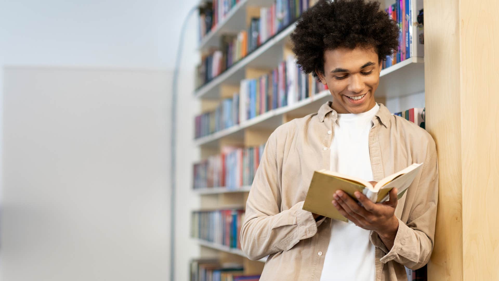 man reading book in the library