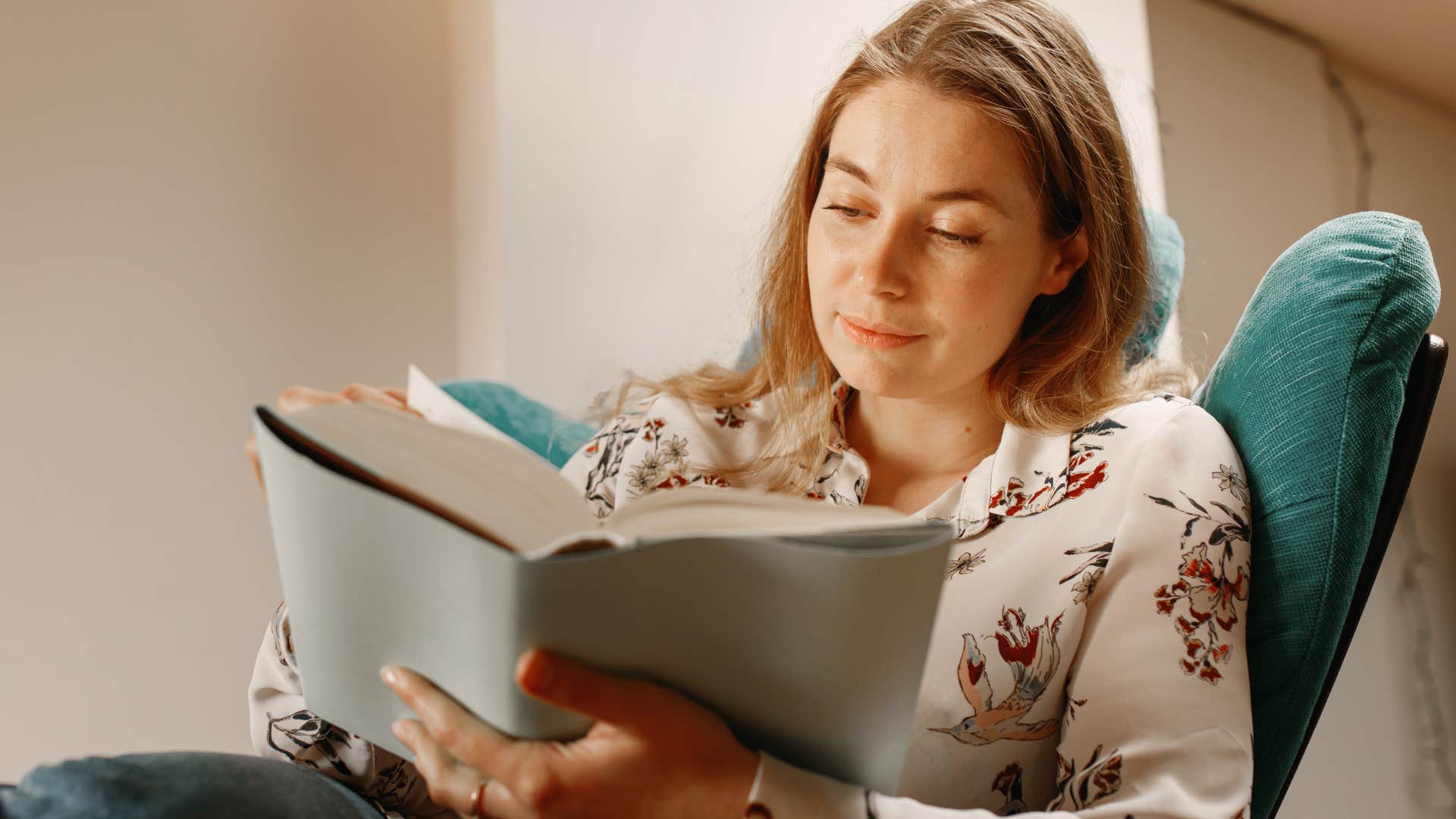 woman reading books she enjoys at home