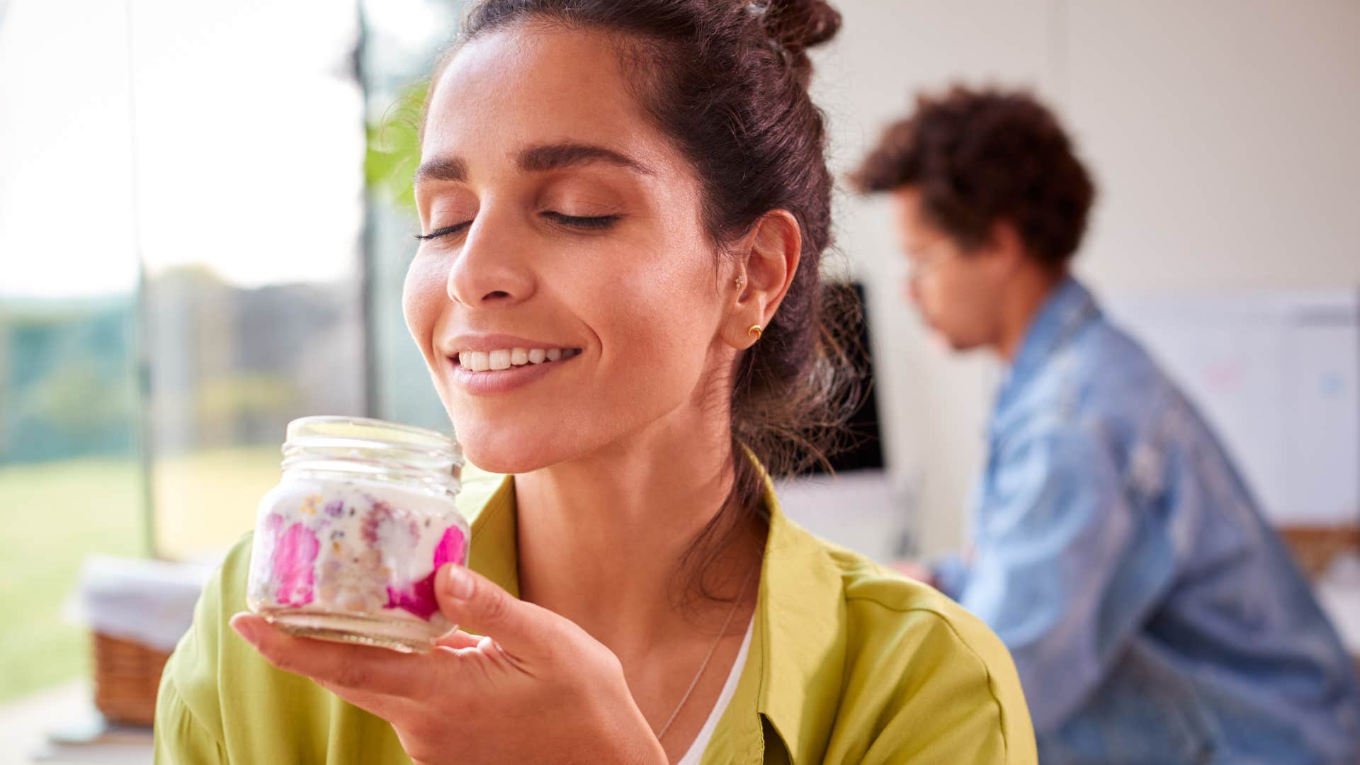 woman smiling and smelling candles