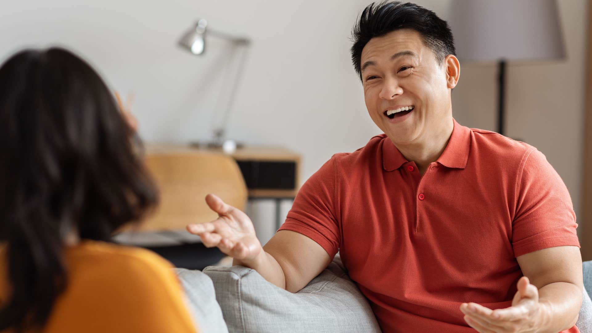 man smiling and talking to a friend in social space