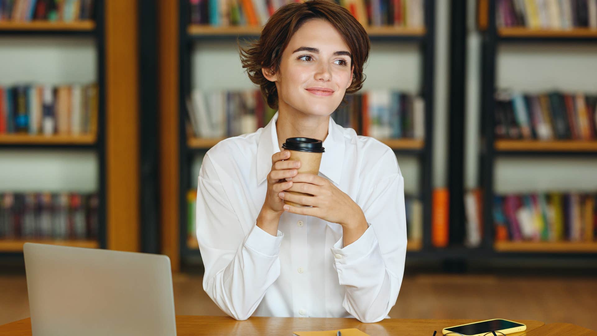 woman sitting in the library after using her library card