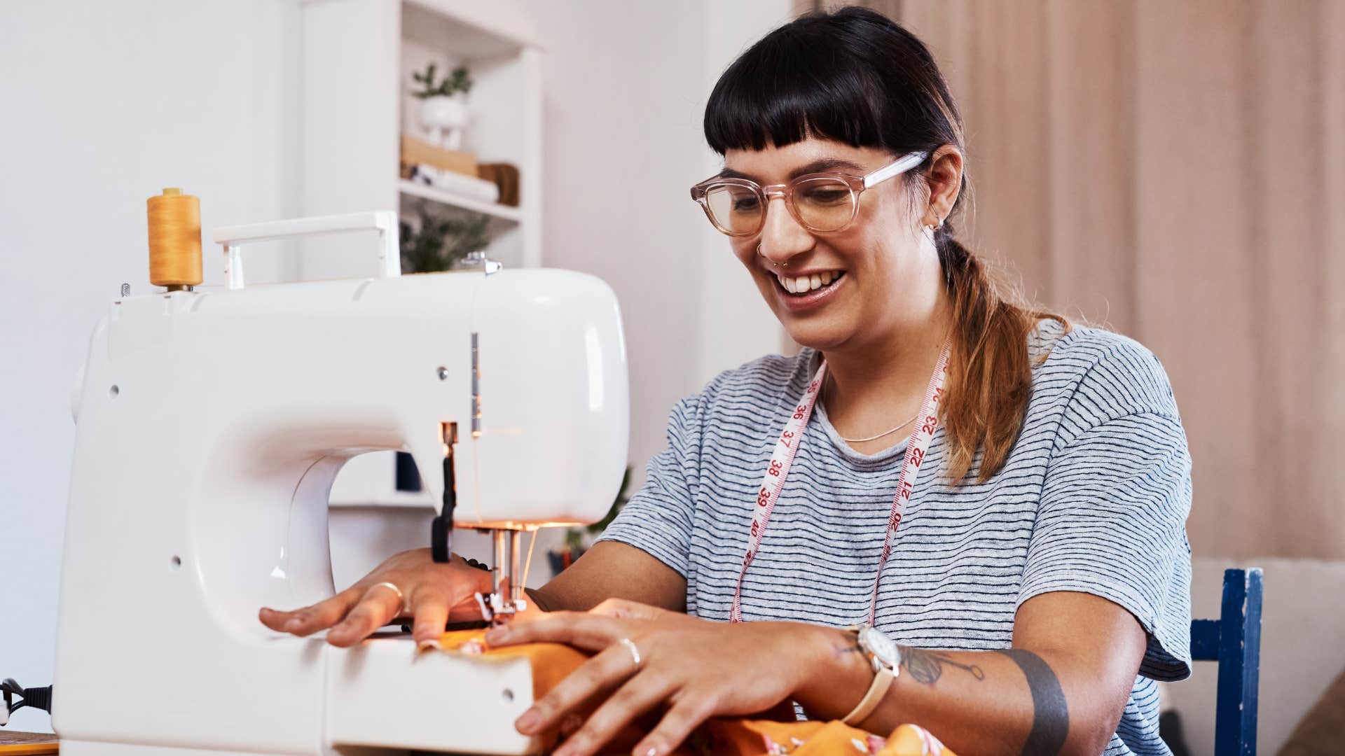 woman using a sewing kit to fix clothing at home