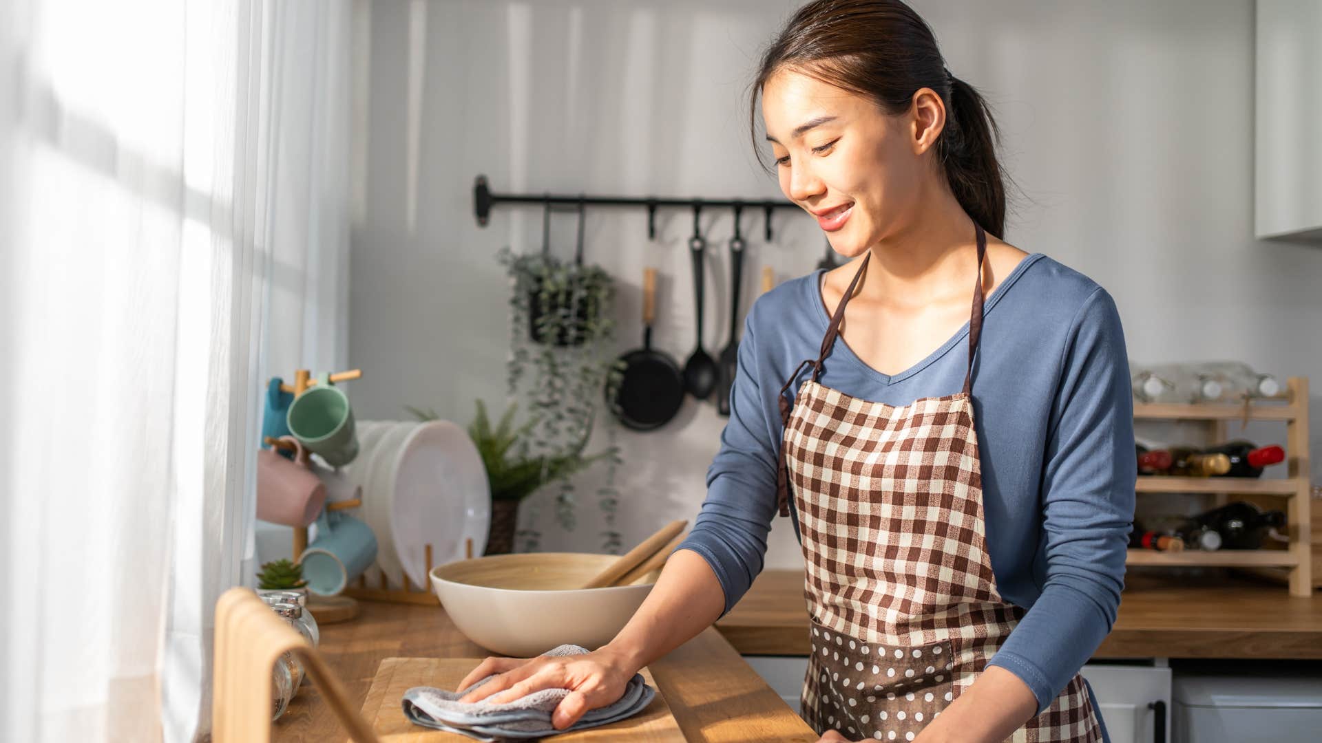 woman cleaning her kitchen with vinegar