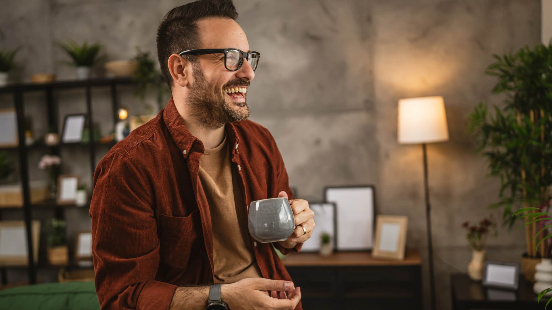 Man sitting in cozy furniture arrangements and laughing.