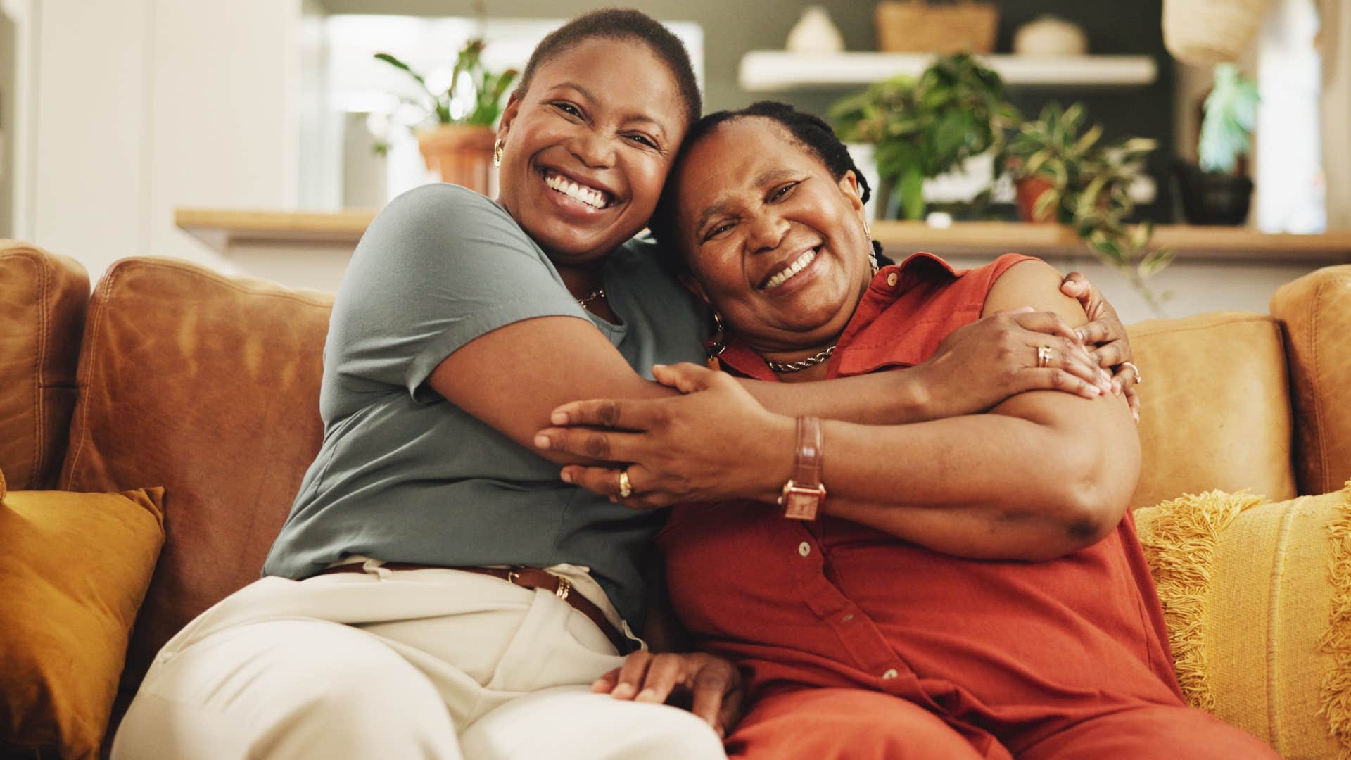Two women smiling and sitting in their safe place at home.