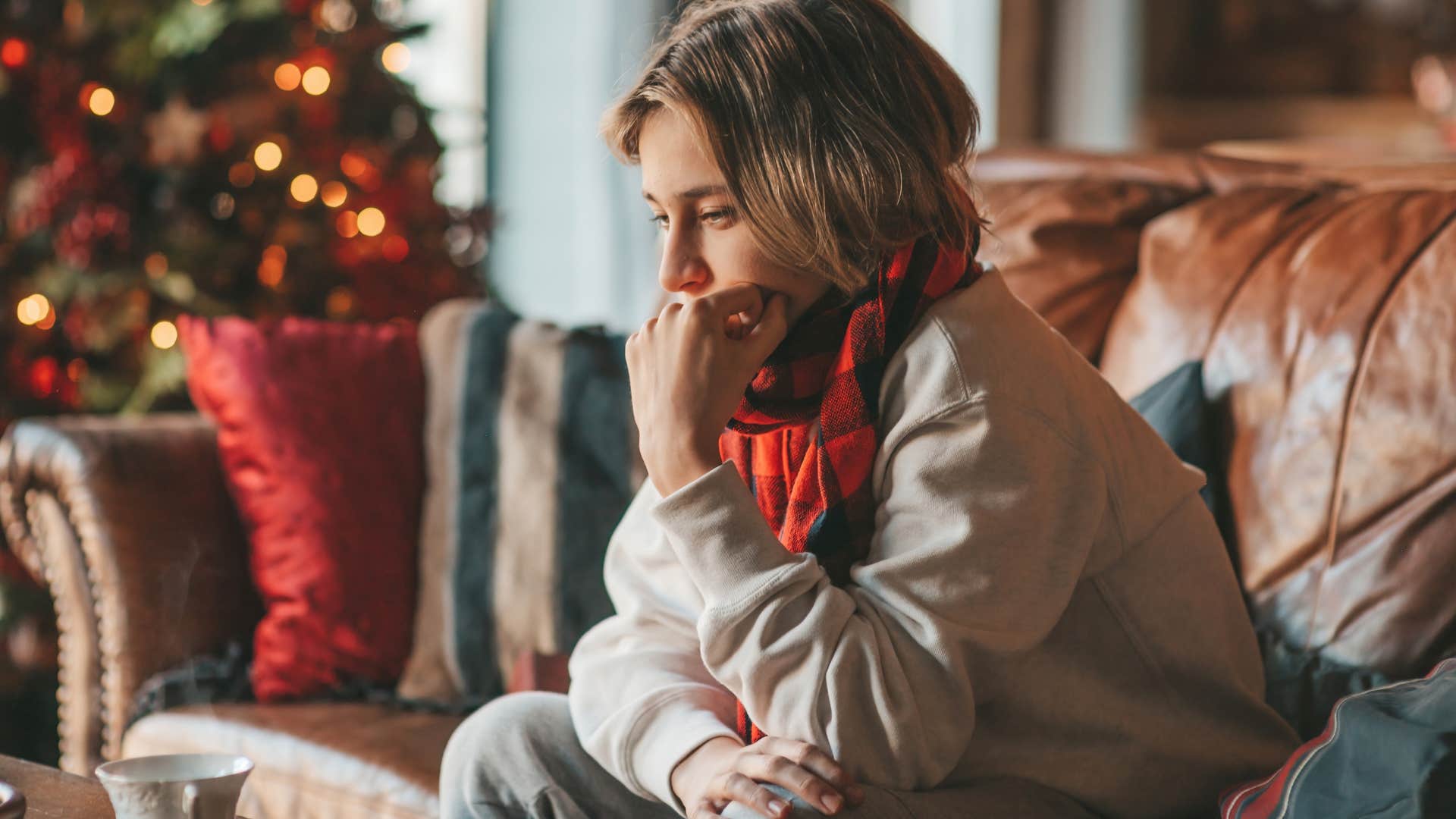 sad person sitting at home around old decorations from holidays