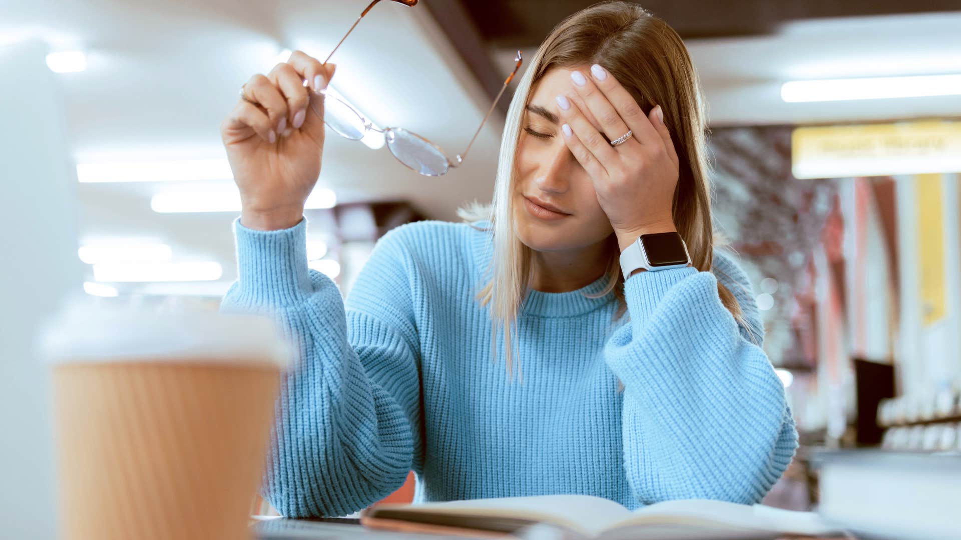 sad woman looking through old journals at home