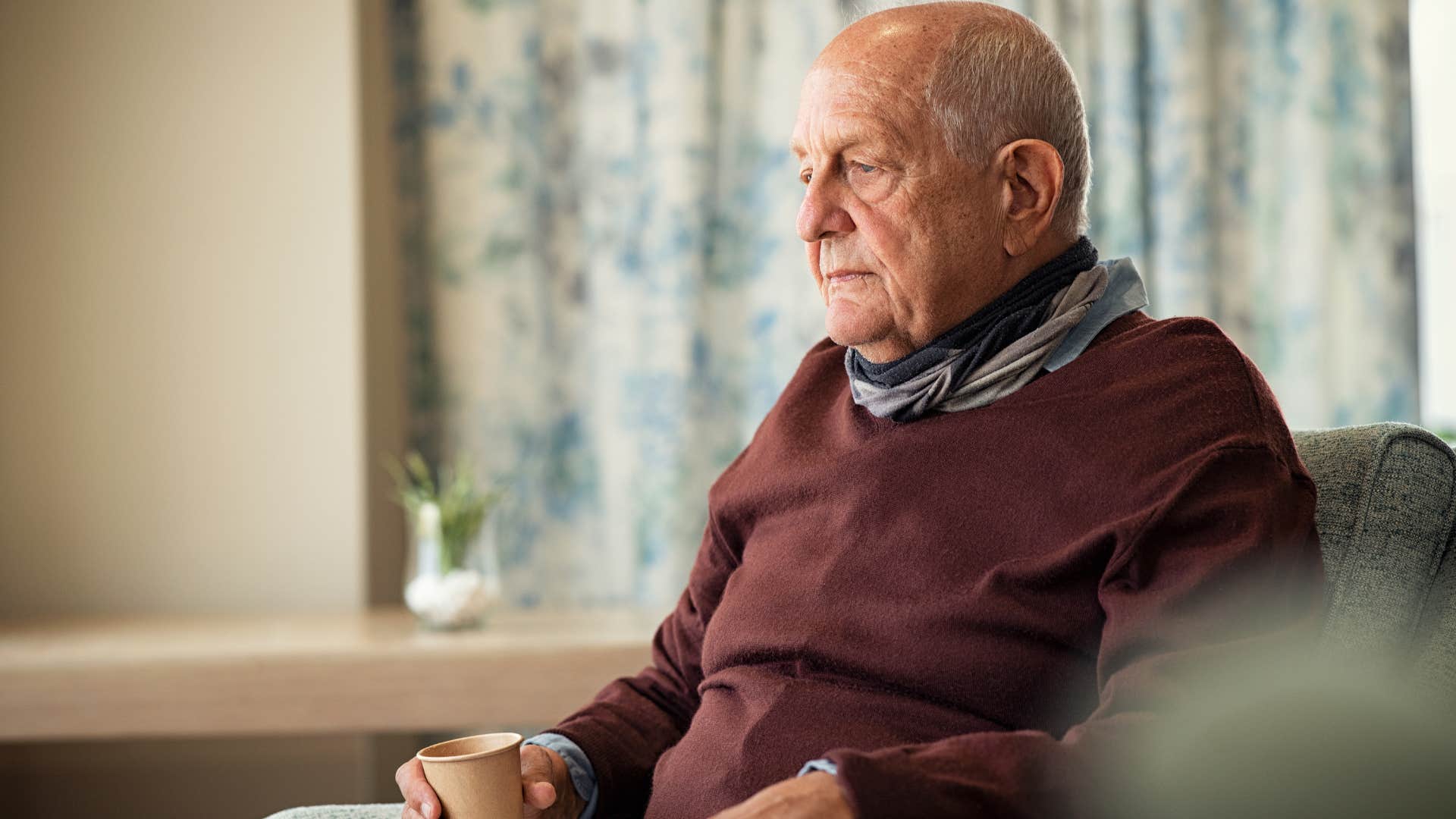 sad man sitting at home thinking about sentimental items