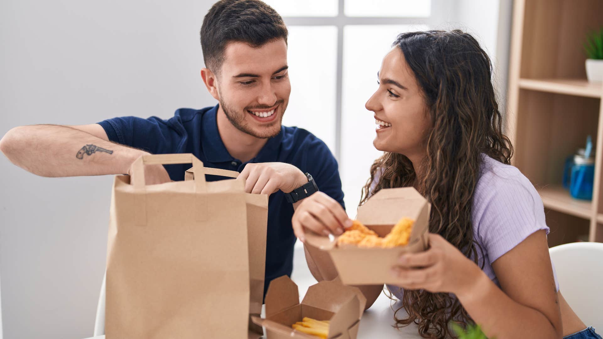 couple smiling holding takeout containers