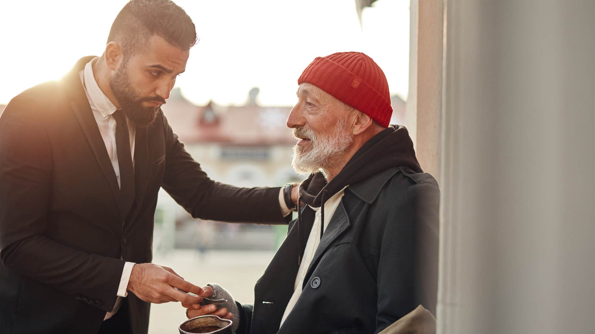 man battling homelessness while talking to stranger on the street