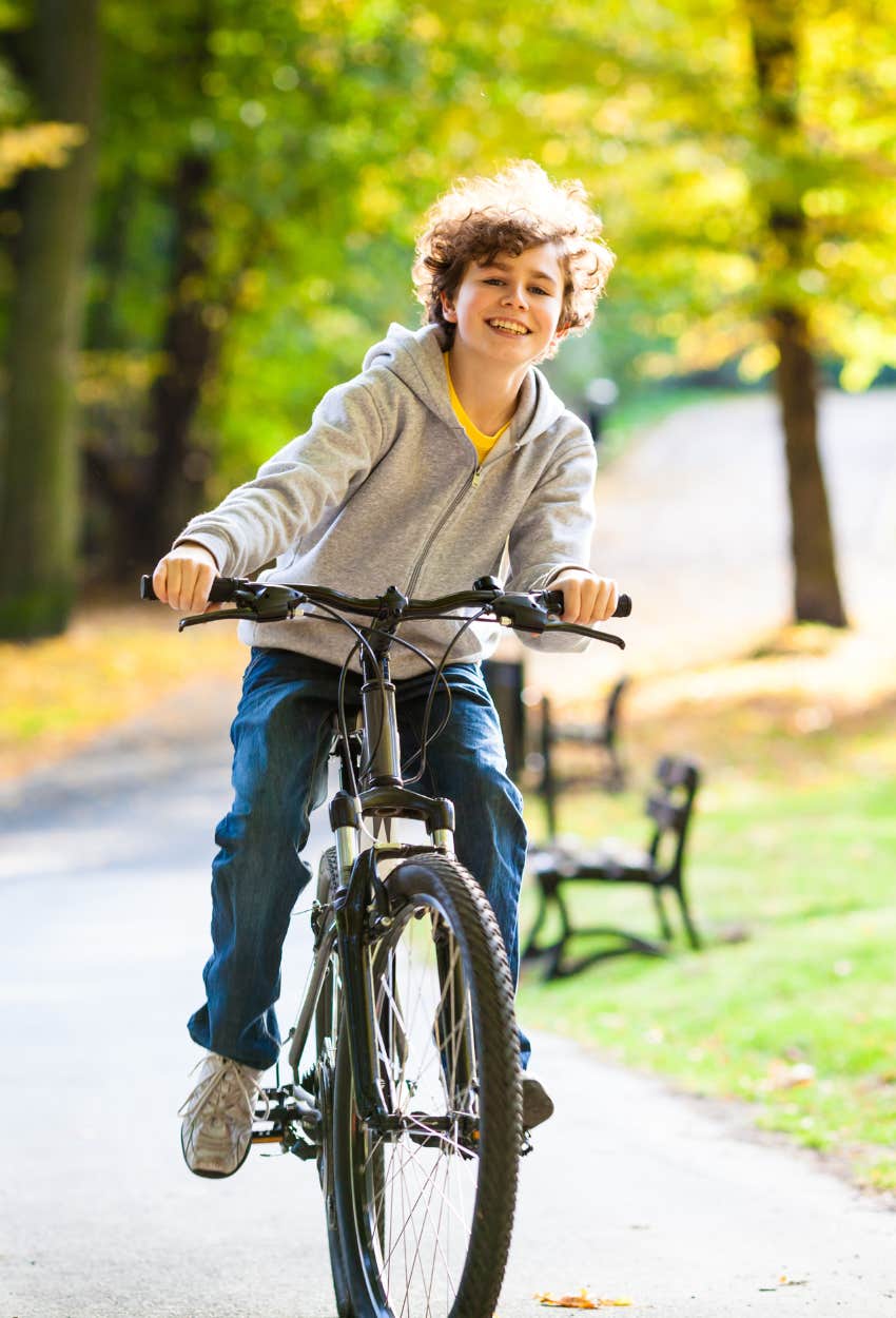 Happy and independent boy riding his bike because his parents are not overprotective