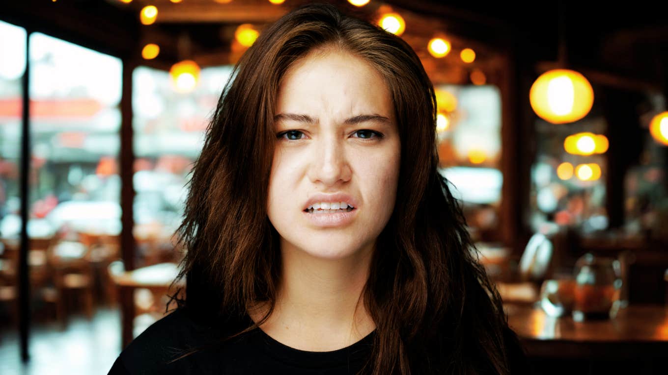 Of People Are Secretly Repelled By This Surprising Food Habit, According To Research Woman at restaurant, repelled by surprising food habit.