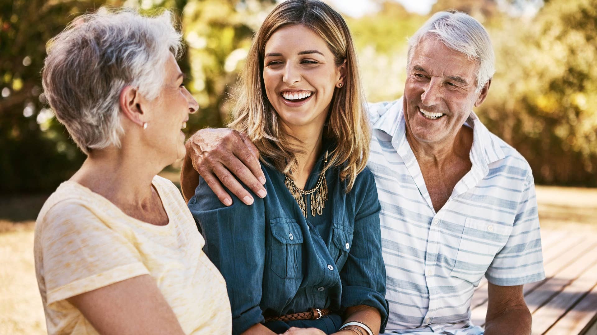 woman who had a healthy childhood smiling with her parents