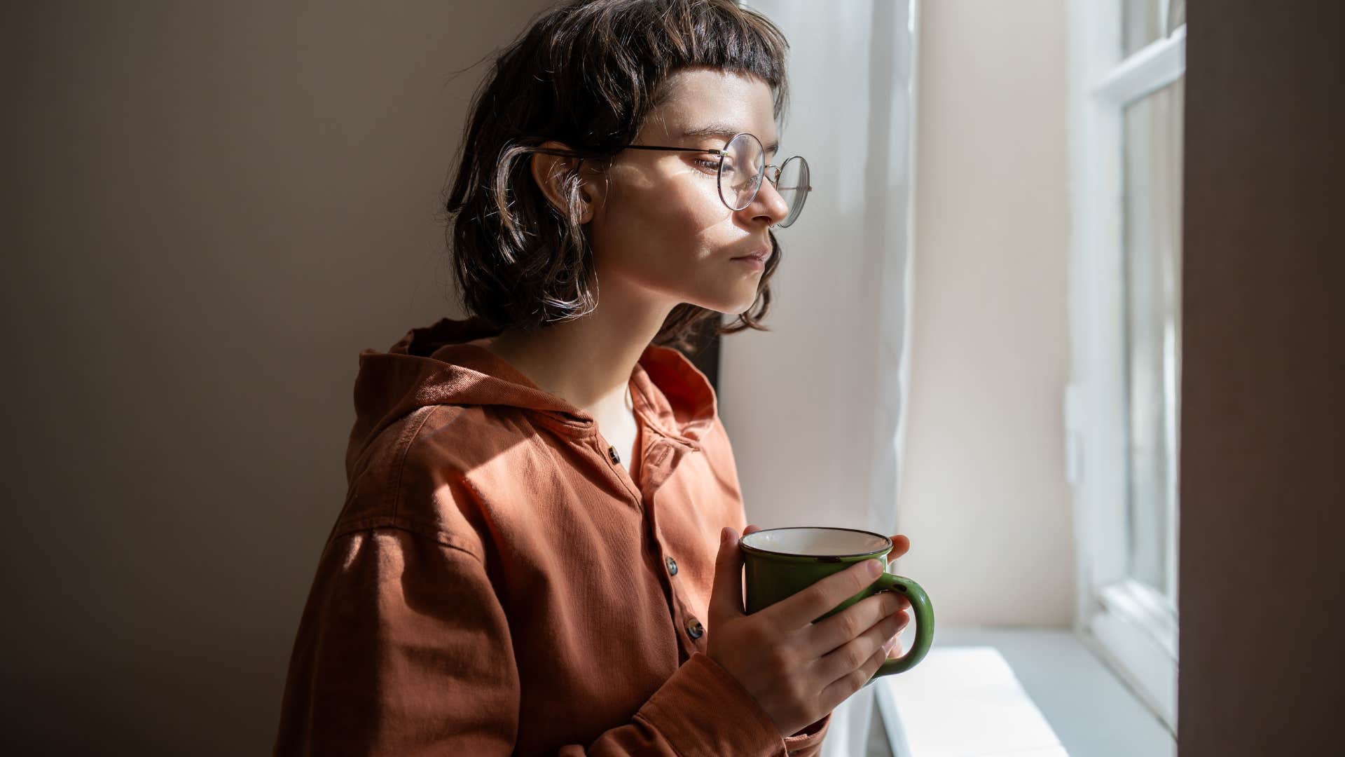introverted woman looking out a window