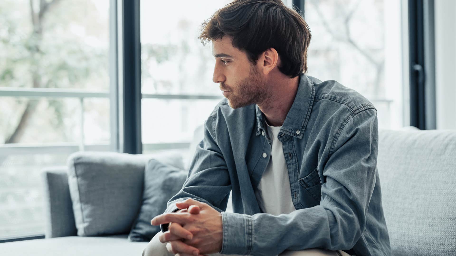man with social anxiety looking out a window