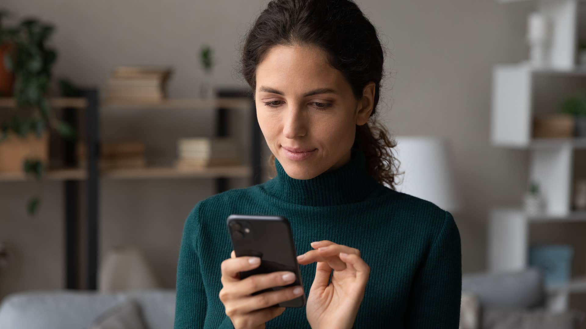 Independent woman smiling and looking at her phone.
