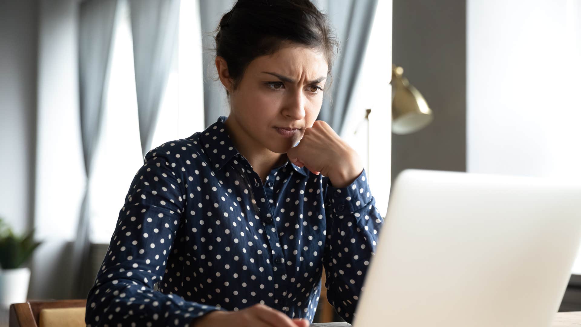 Anxious woman typing on her laptop.