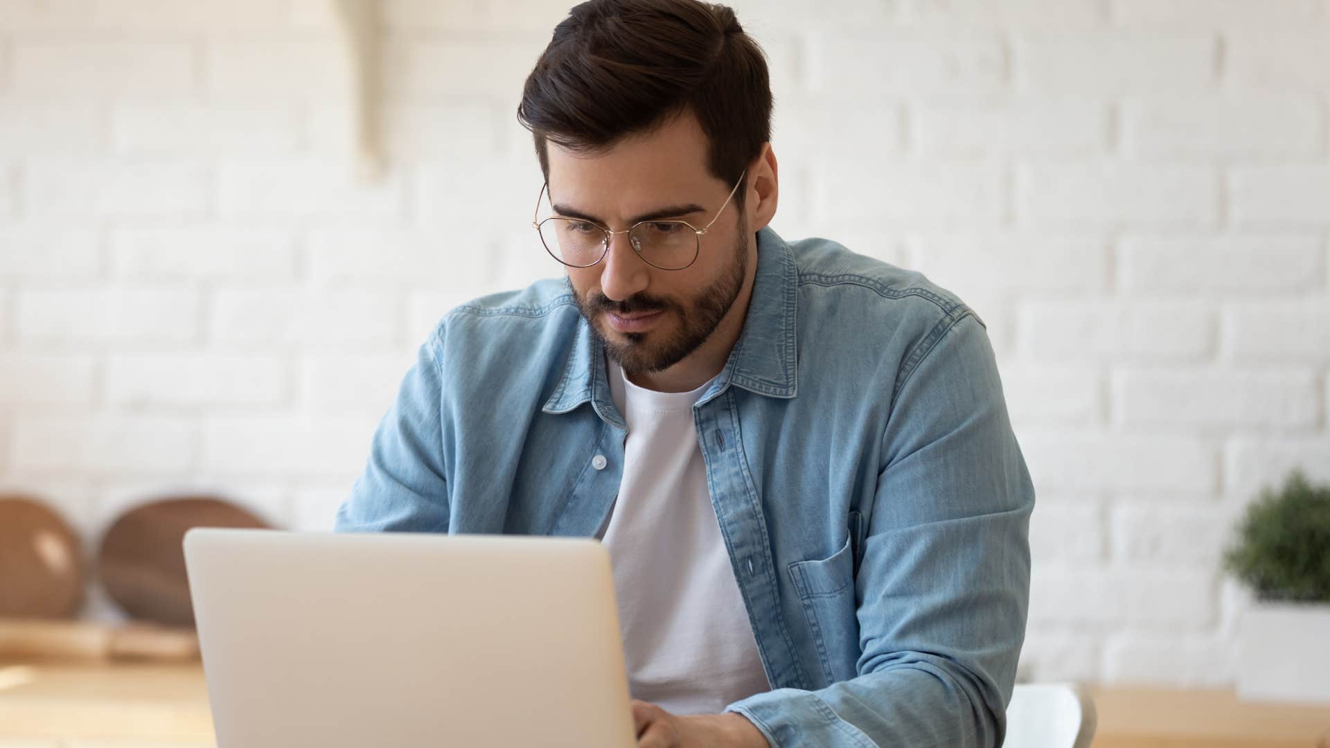 Man who struggles with multitasking working on a laptop.