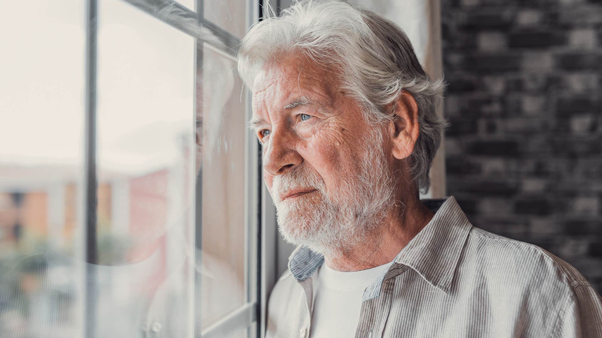 older man with strong boundaries looking out a window