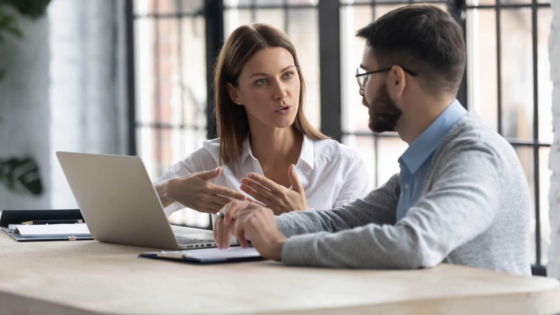 woman in white shirt telling man in blue shirt let's catch up another time
