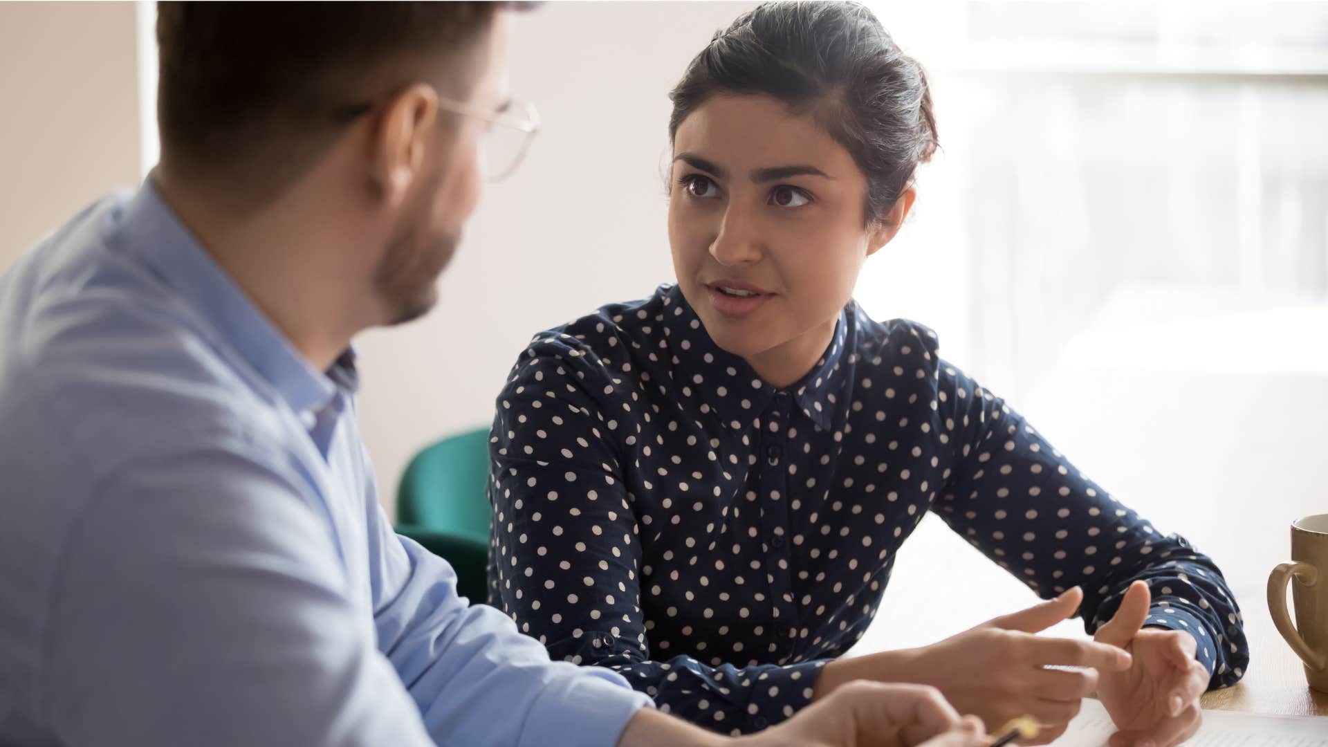 woman in polka dot shirt telling coworker i think we might be getting off track what did you come here to discuss