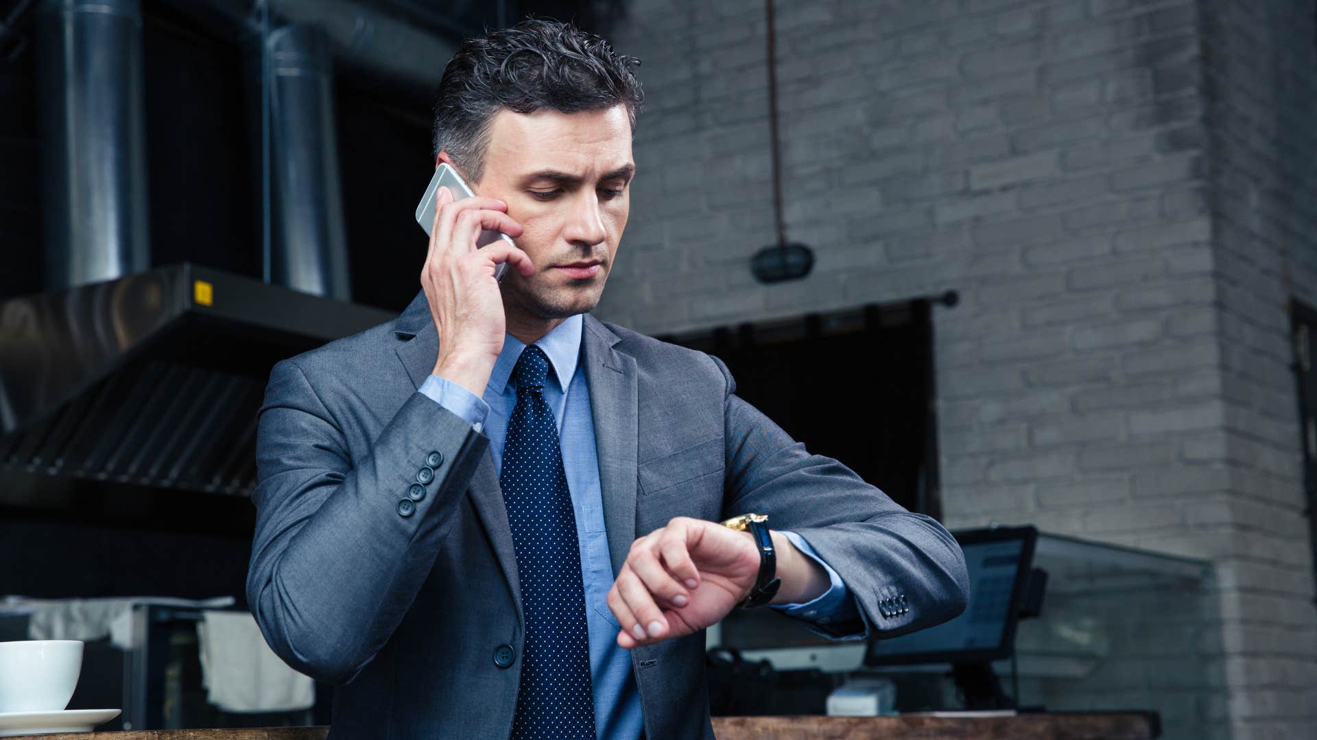 man in suit on phone looking at watch can you summarize the main point since i'm running out of time