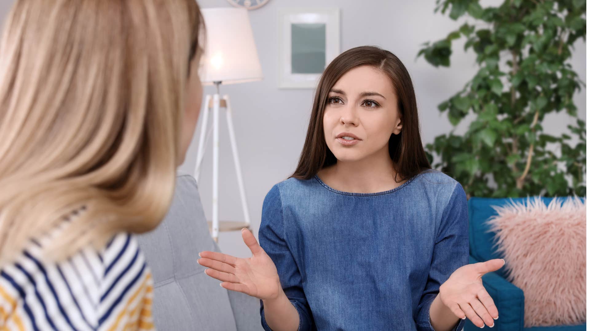 friend in denim shirt telling woman in stripped shirt she needs to calm down