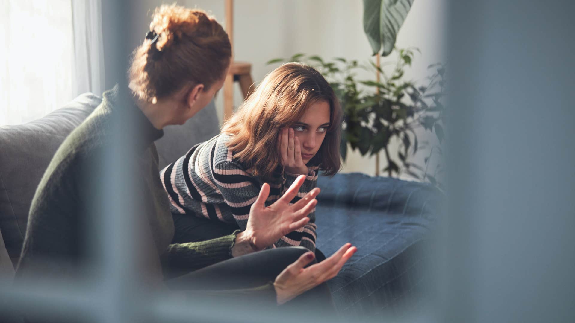 mom in dark sweater telling annoyed stripped shirt daughter if i were you