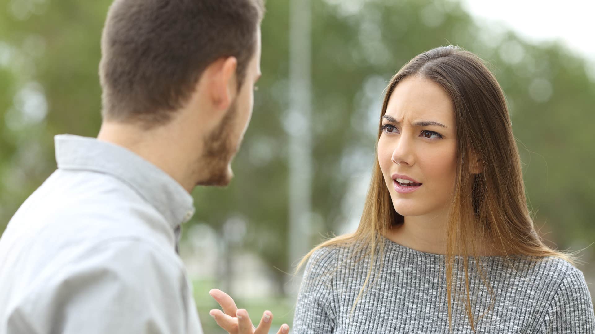 man in white shirt saying you owe me as woman in gray shirt argues back with a look of disgust on face