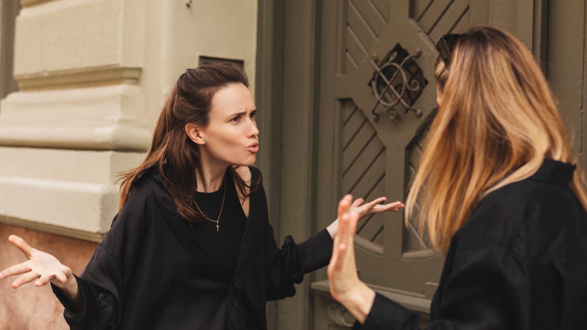 woman in black shirt shrugging in confusion as she says i don't see what the big deal is to woman who's clearly offended and angry
