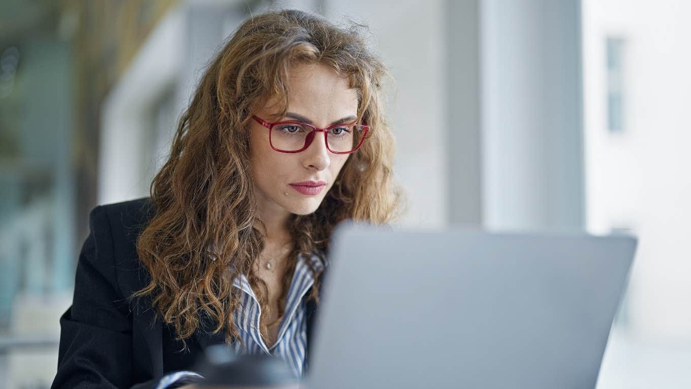 Phrases In Job Descriptions That Mean You’ll Be Overworked And Undervalued woman reading job description with phrases that mean she'll be overworked and undervalued