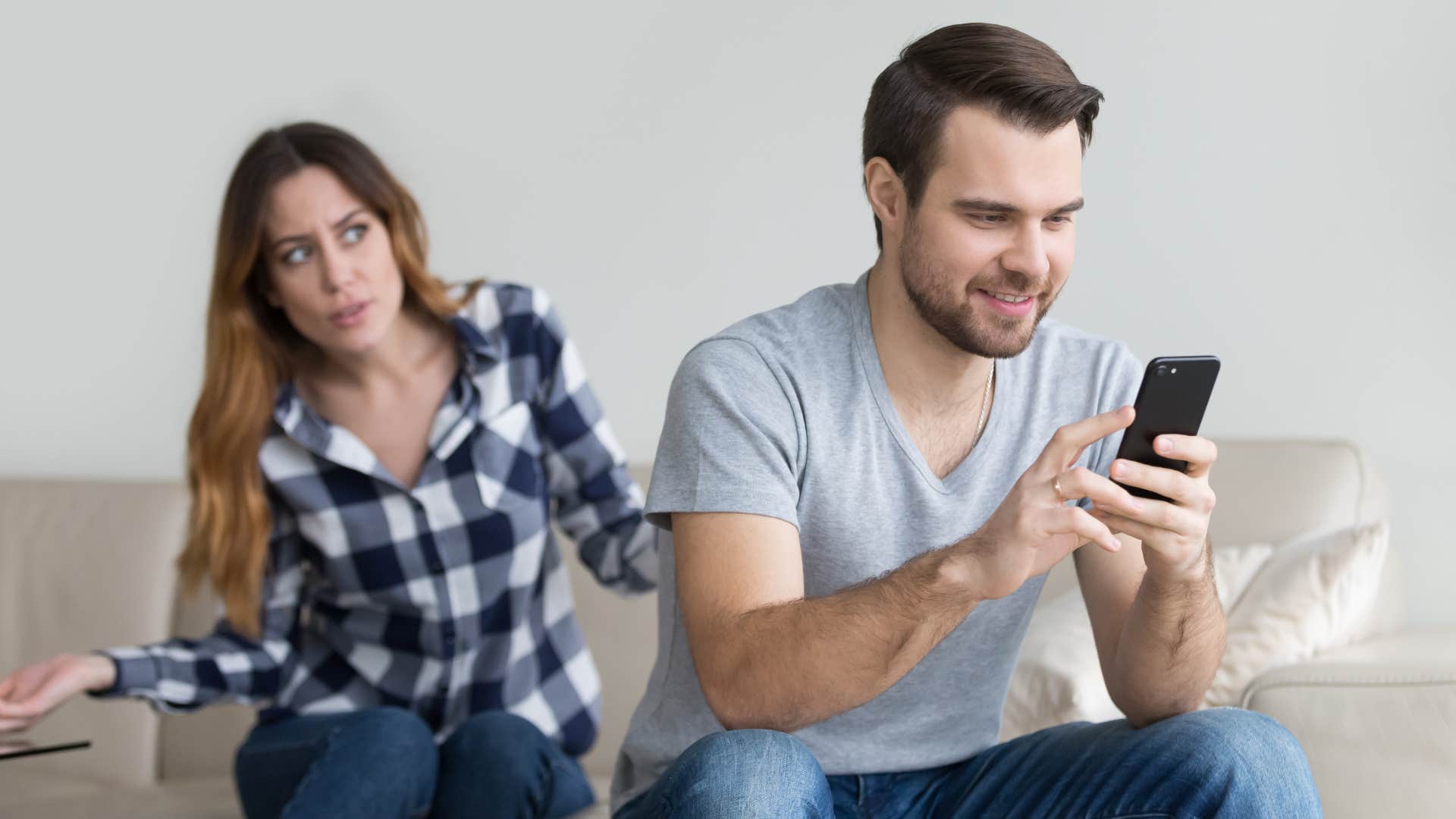 man in gray shirt on phone ignoring pleading wife as he says he'll get to it later
