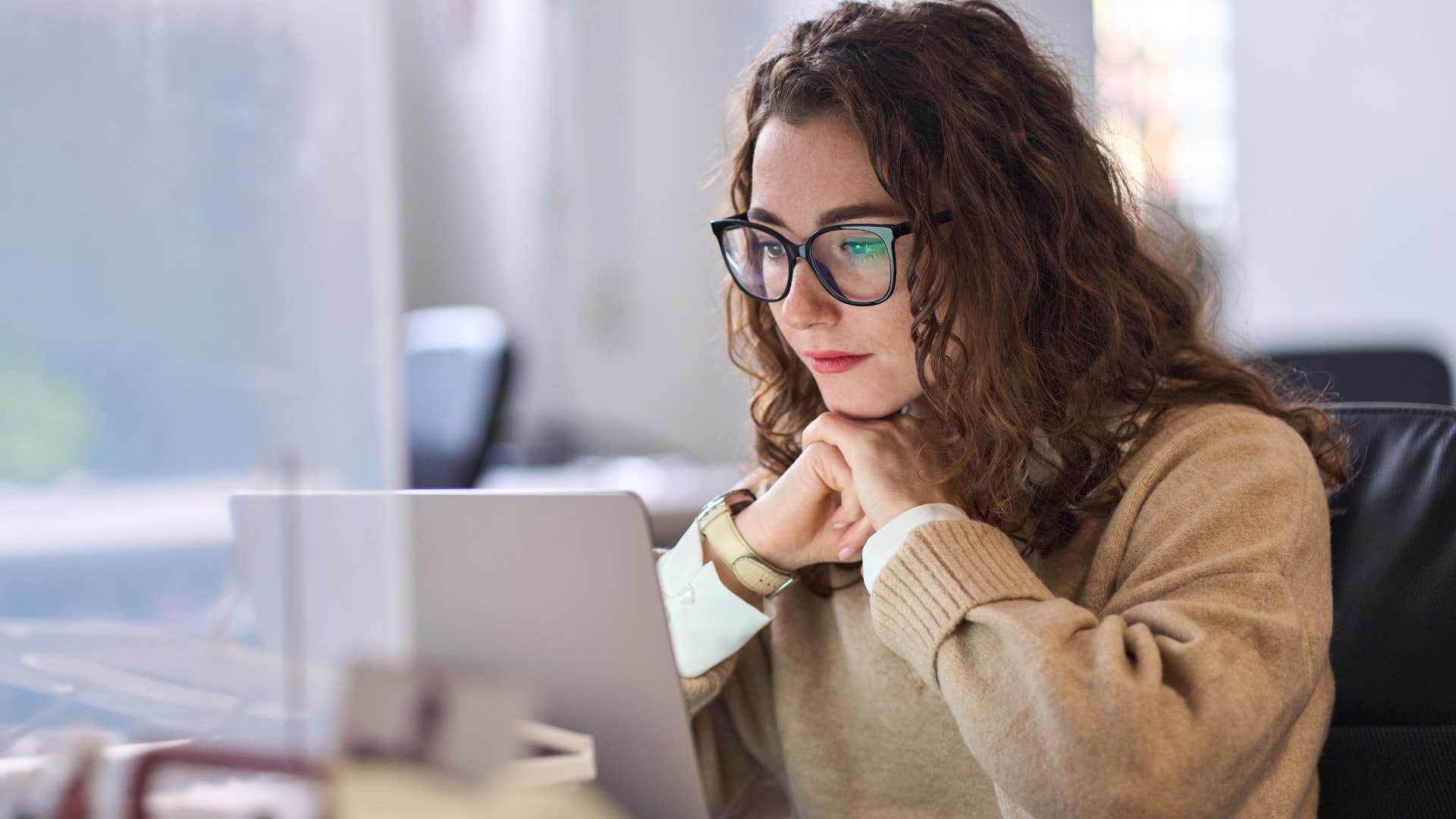 woman thinking I've been through worse while looking at her laptop