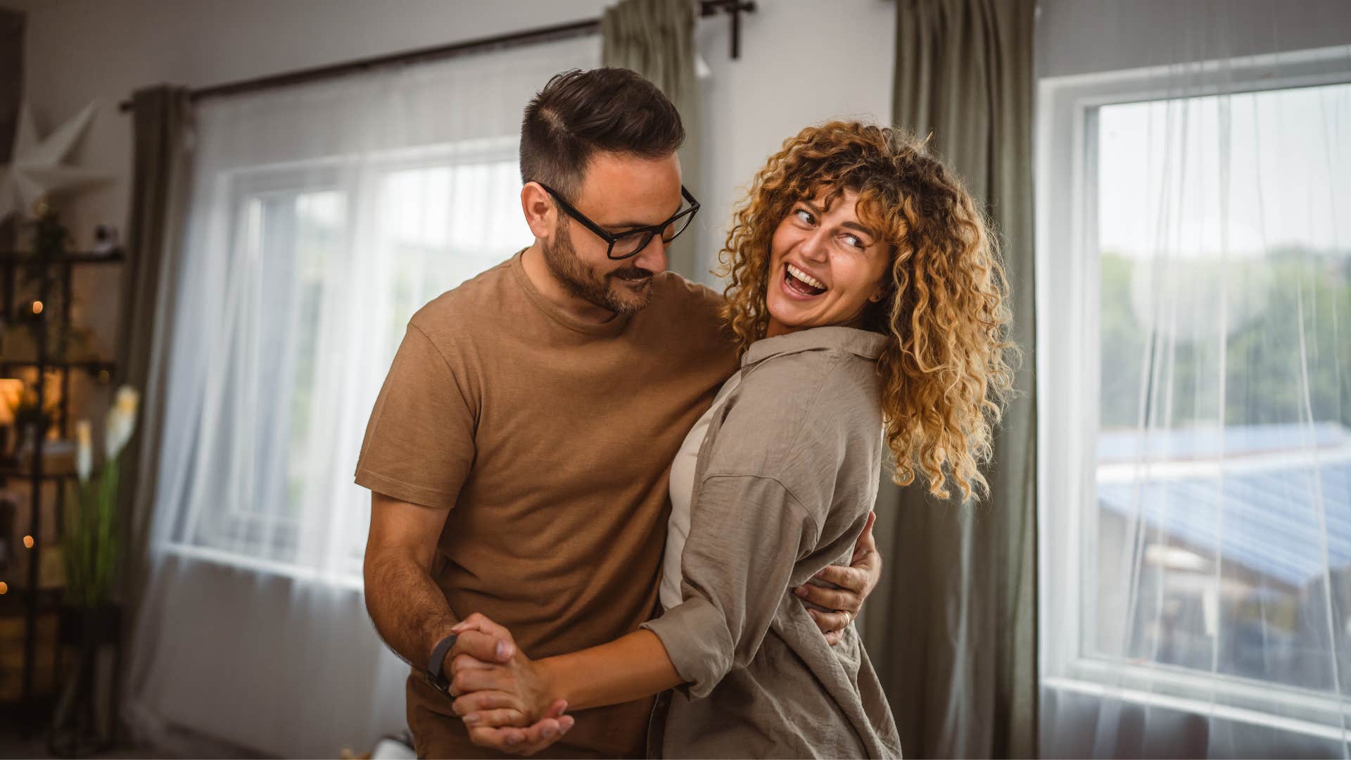 a man guides his woman in a dance