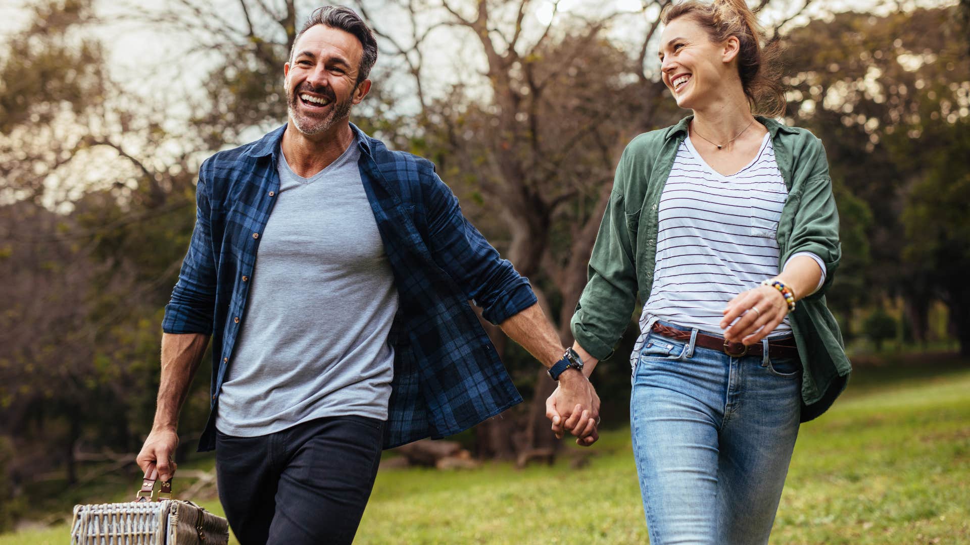 couple holding hands and smiling as they feel like they're growing side by side in the relationship