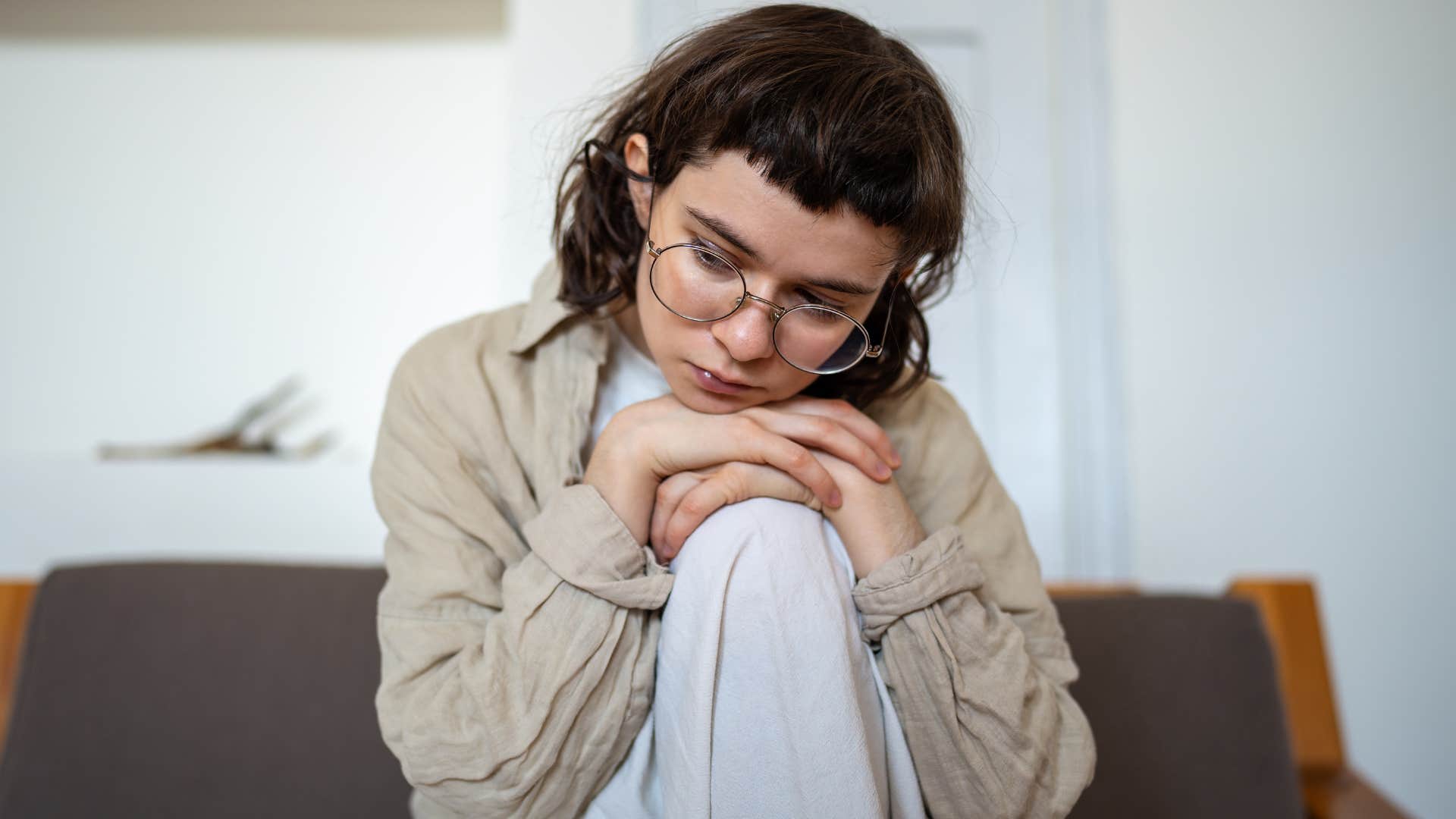 woman who fears being judged sitting at home alone