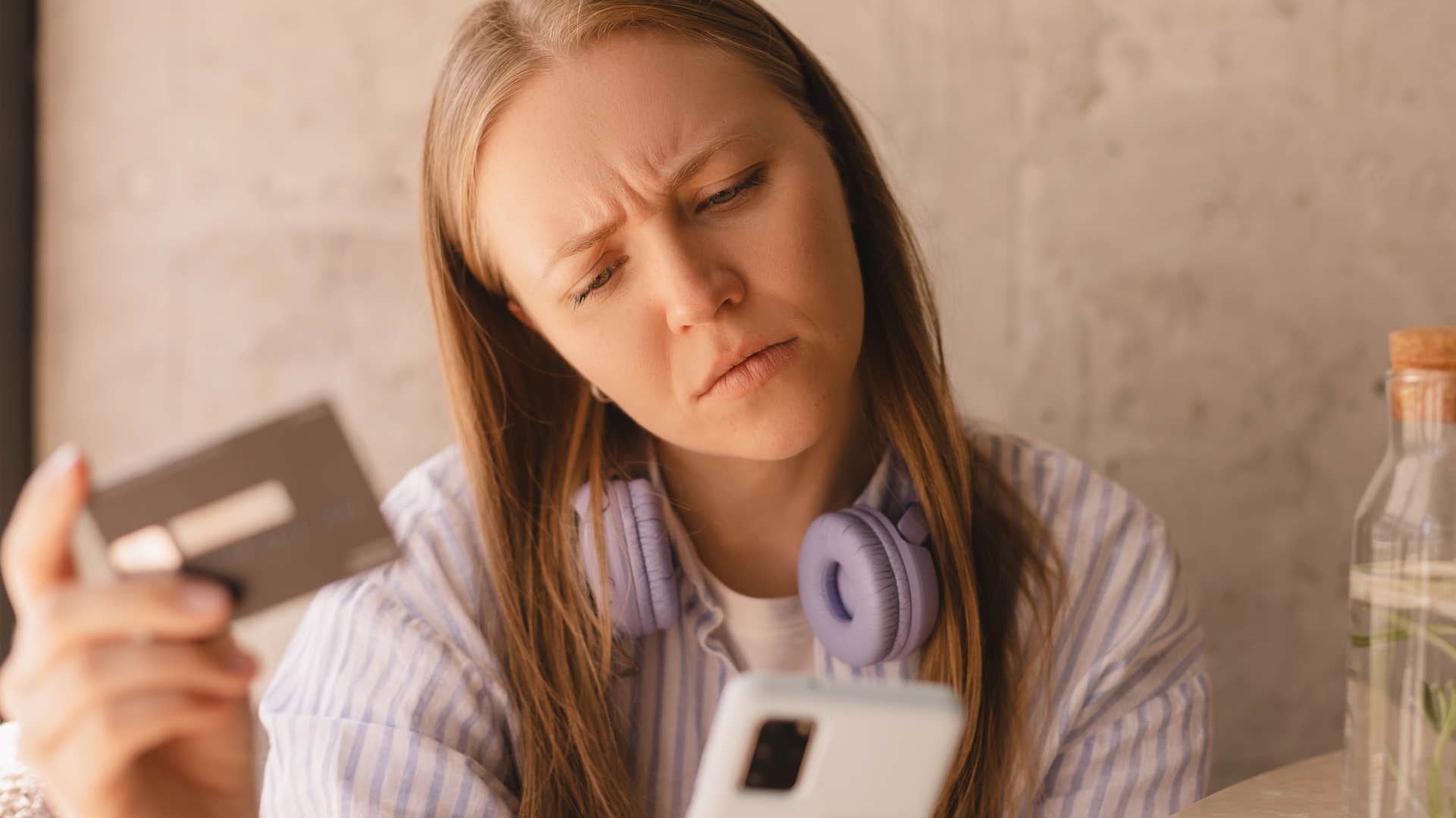 woman worried about hidden fees holding her credit card
