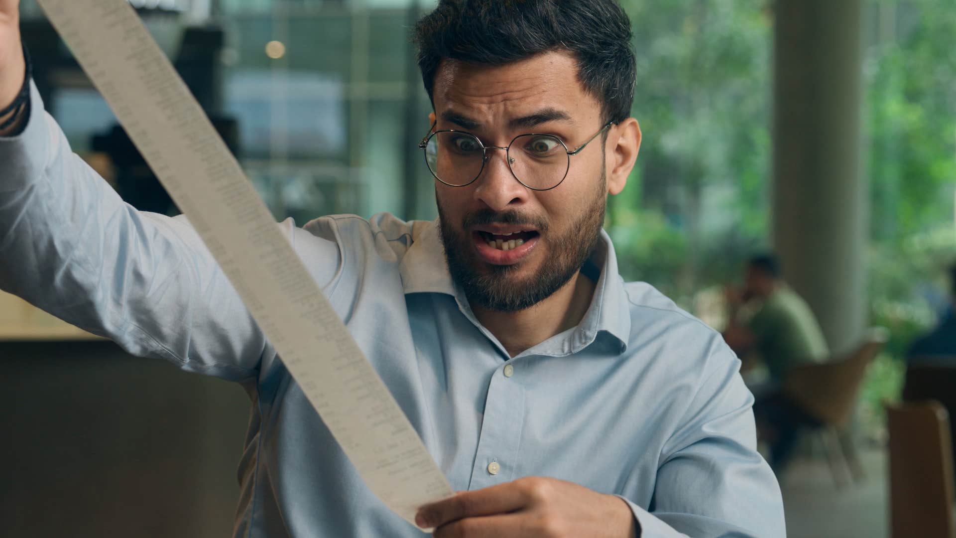 man who doesn't want to seem difficult looking at a receipt