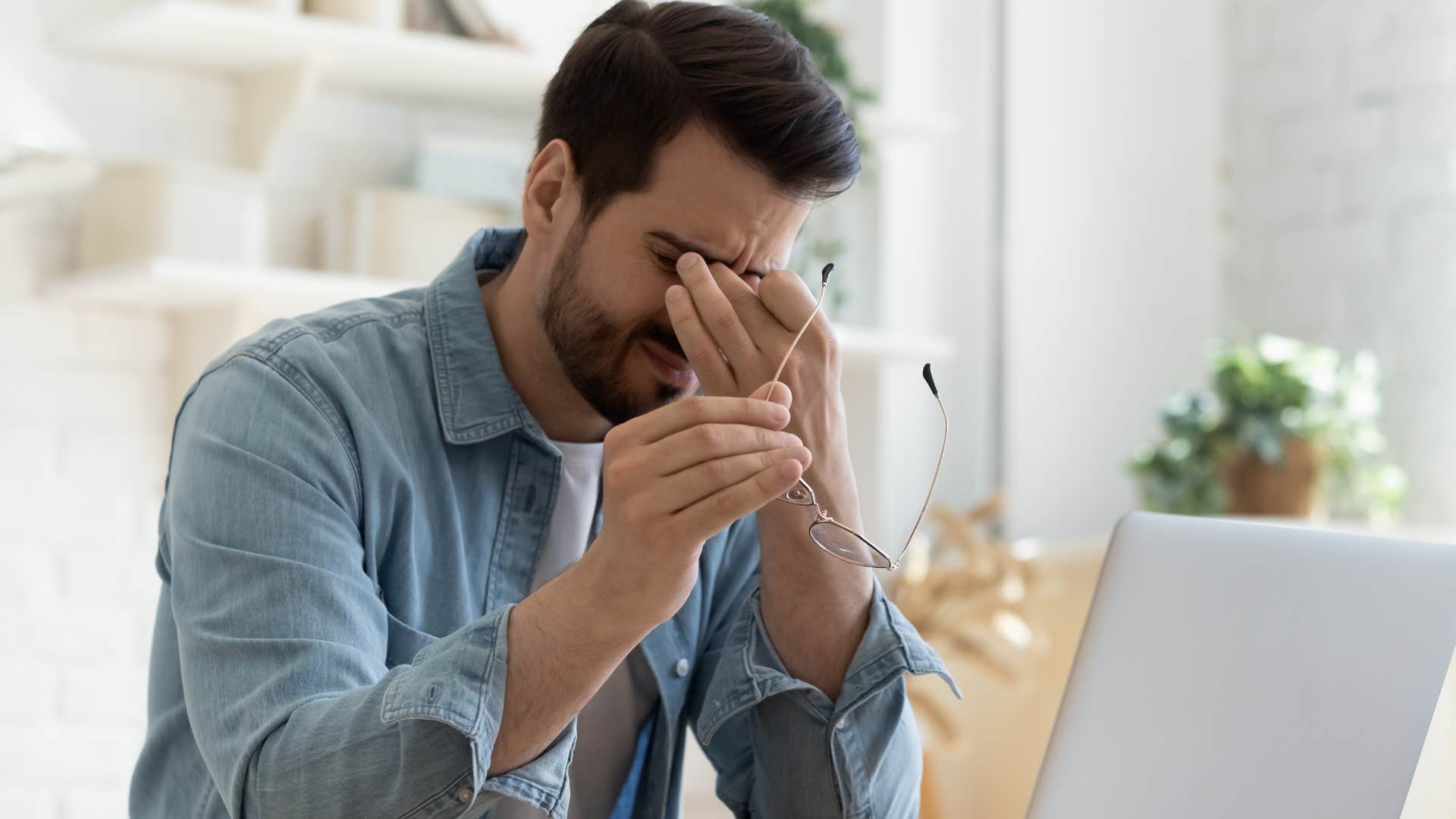 Man whose jobs are too stressful holding his head.