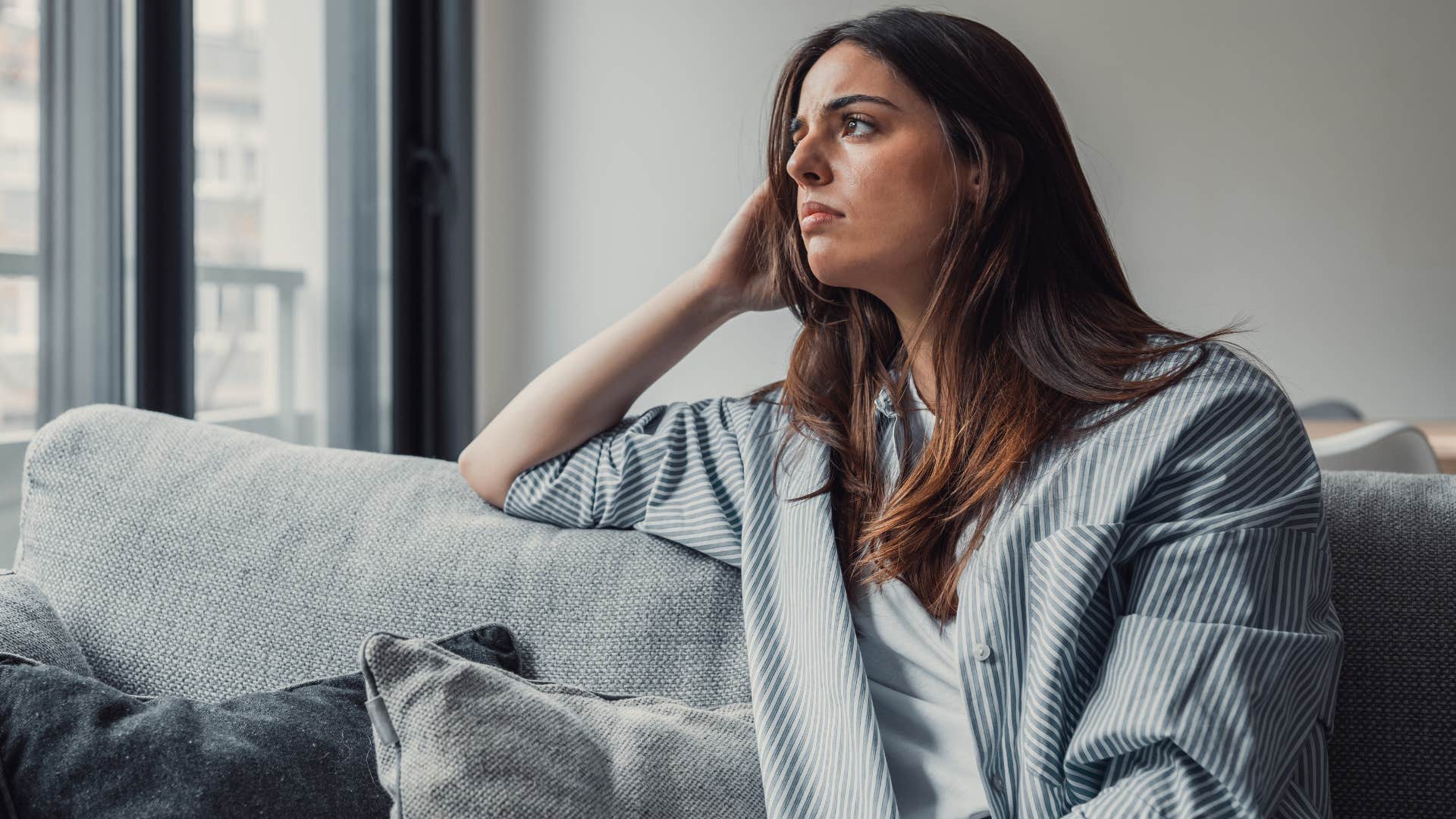 Woman who lacks community looking sad at home.
